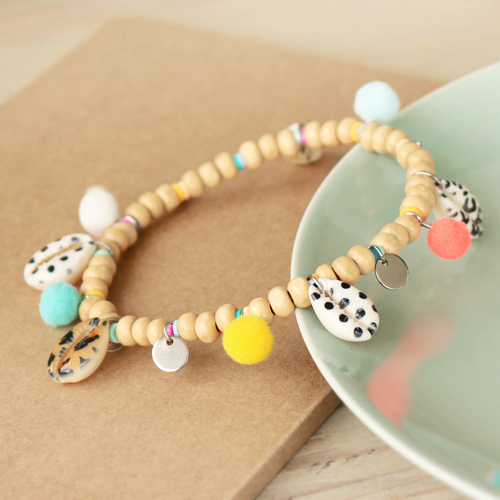 Scopri qui come creare i migliori bijoux con conchiglie ciprea e ciondoli pon pon